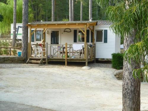 a tiny house in the woods with a porch at ZEcamping 4 étoiles animaux acceptés avec piscine chauffée toboggan et tennis in Ucel