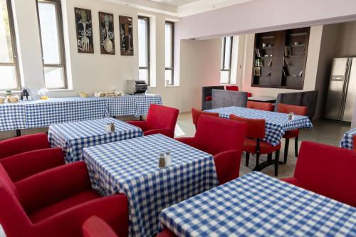 een restaurant met blauwe en rode tafels en stoelen bij New Gate Hostel in Jeruzalem