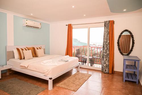 a bedroom with a bed and a large window at Kieh Beachfront Villa in Mandrem