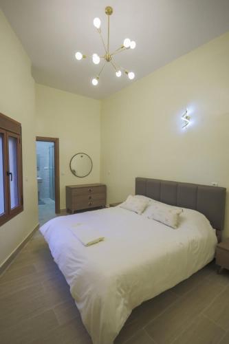 a bedroom with a large white bed and a chandelier at COZY APPARTEMENT Center city 11 janvier in Casablanca