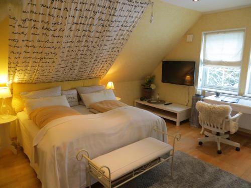 a bedroom with a large bed and a desk at bettis Tostedt in Tostedt