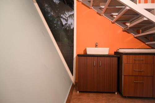 a bathroom with a sink and an orange wall at Kieh Beachfront Villa in Mandrem