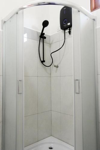 a shower with a shower head in a bathroom at Coral Waves Inn - Pasikuda in Kalkudah
