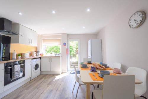 a kitchen with a table and a clock on the wall at Stylish Stirling home with stunning views in Stirling