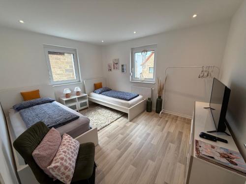 a small room with two beds and a television at Schön, praktisch & zentrale Lage in Bergrheinfeld