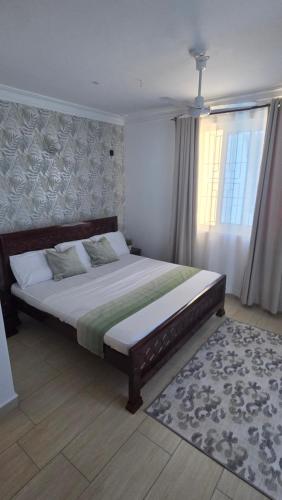 a bedroom with a large bed and a window at Seasalt & Sand in Mtwapa