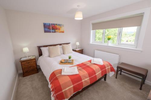 a bedroom with a large white bed and a window at Stylish Stirling home with stunning views in Stirling