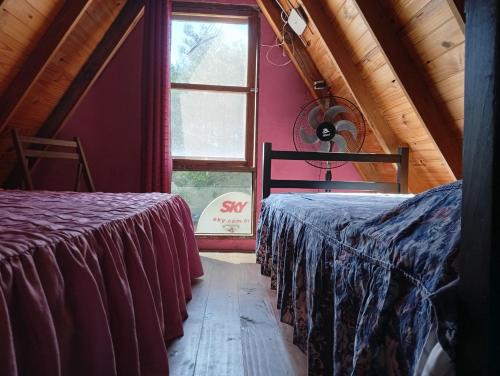 two beds in a room with a window at De Férias na Fronteira in Xuí