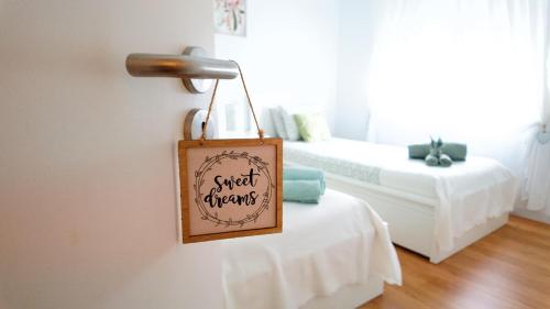 a sign hanging on a wall next to a bed at BENAMAR HOUSE in Quarteira