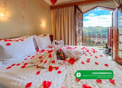 a bedroom with a bed with red roses on it at Hotel Nacional Inn Campos do Jordão in Campos do Jordão
