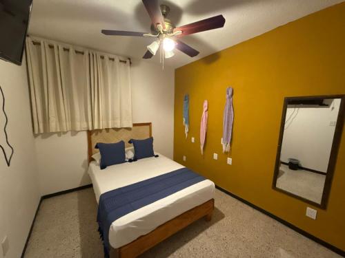 a bedroom with a bed and a ceiling fan at HOSTAL CHOCOLATE CALENDA in Oaxaca City