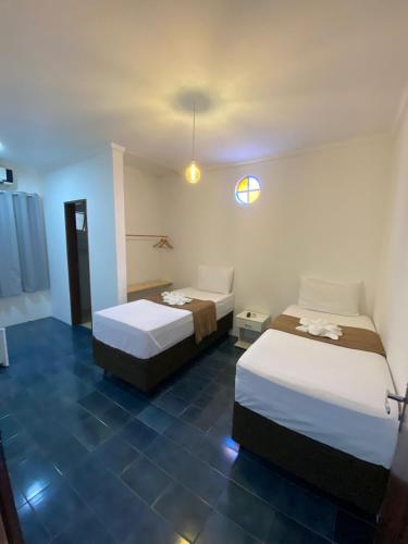 a bedroom with two beds and a blue tile floor at Santa Ana da Ribeira in SantʼAnna do Ipanema