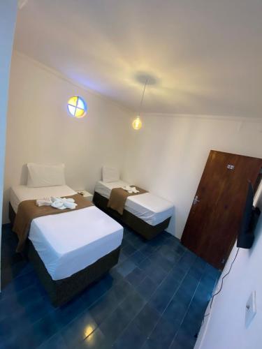 a hotel room with two beds and a tv at Santa Ana da Ribeira in SantʼAnna do Ipanema