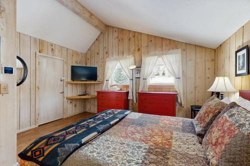 a bedroom with wooden walls and a bed and a television at Bear's Crossing Retreat in Dover