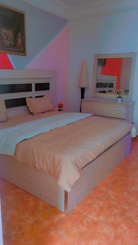 ein Schlafzimmer mit einem großen Bett in einem Zimmer in der Unterkunft Emirimmo in Dakar