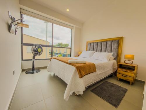 a bedroom with a bed with a window and a fan at Casa Turística en el Quindío in La Tebaida