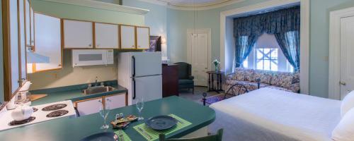 a kitchen and living room with a refrigerator and a table at Chipman Hill Suites -Yeats House in Saint John