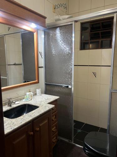 a bathroom with a sink and a shower at Equilíbrium Quarto de casal com banheiro compartilhado in Marechal Cândido Rondon