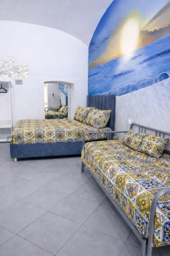 a room with two beds and a painting on the wall at Aurora Flavia Suite in Pozzuoli