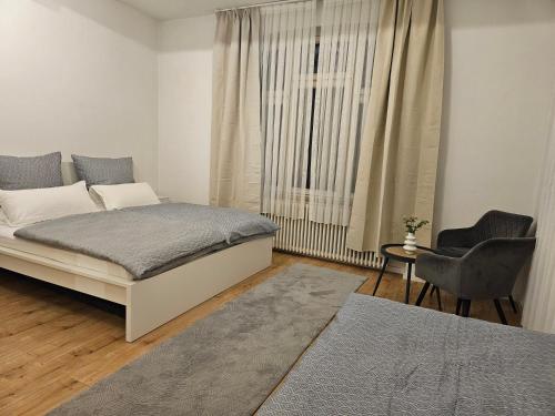 a bedroom with a bed and a chair and a window at Sero`s Apartment in Hahnstätten
