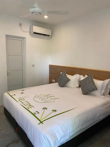 a bedroom with a large white bed with a flower on it at Amaria Maldives in Finolhus