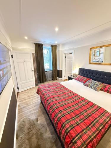 a bedroom with a large bed with a plaid blanket at Whisperwood Apartment in Colnrade