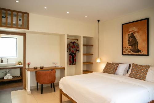 a bedroom with a bed and a desk and a sink at The Nest - Complimentary Massage Included in Kigali