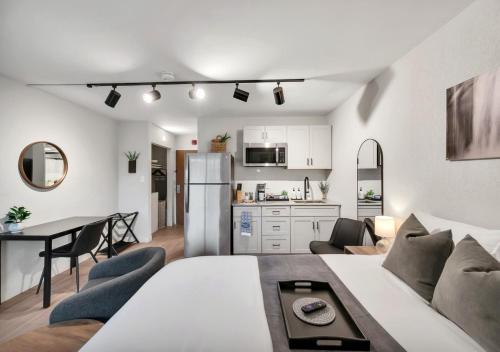a living room and kitchen with a couch and a table at Modern Midtown Studio and Private Balcony in Raleigh