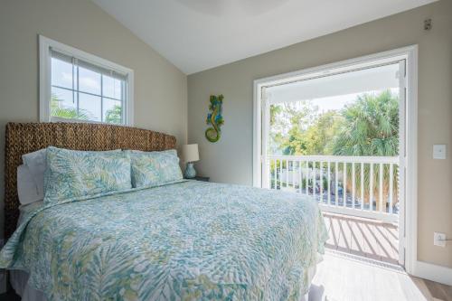 a bedroom with a bed and a large window at ISLAND TIME ON THE GREEN in Key West
