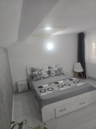 a bedroom with a bed in a white room at Ramhouse in Piteşti