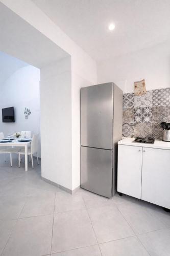 a kitchen with a stainless steel refrigerator and a table at Diana Flavia Suites in Pozzuoli