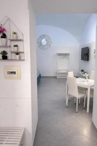 a dining room with a white table and white chairs at Diana Flavia Suites in Pozzuoli
