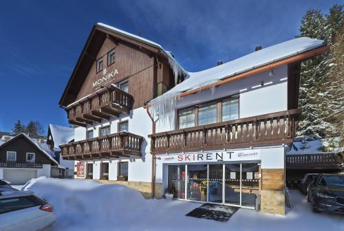 a ski resort building with snow on the ground at King size apartmán Pension Monika in Špindlerův Mlýn