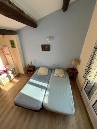 una camera da letto con due letti in una stanza di studio haki a Sète