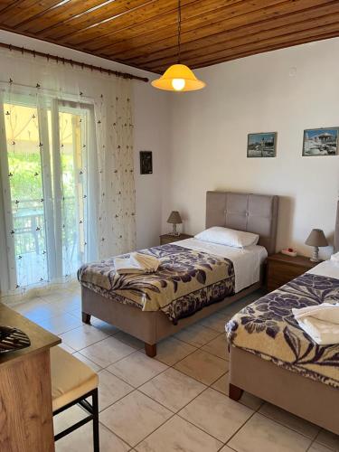a bedroom with two beds and a table at Poseidon Beach Bar & Restaurant Apartments in Paleokastritsa