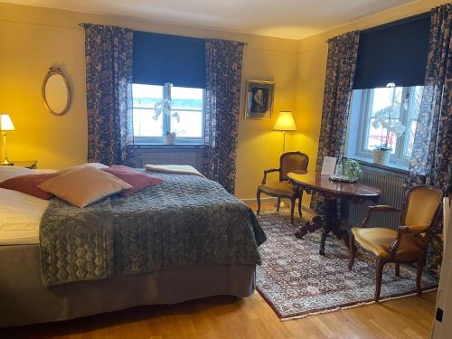 una camera da letto con un letto, un tavolo e delle sedie di Hotell Laurentius a Strängnäs