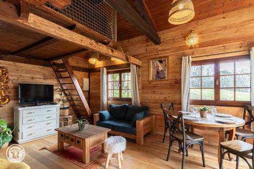 a living room with a dining room table in a cabin at Petit chalet l Authentique Annecy in Dingy-Saint-Clair