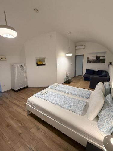 a bedroom with a large bed and a living room at Panzió Apartments in Budapest