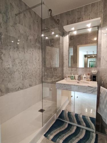 a bathroom with a glass shower and a sink at Victoria Plaza in Menton