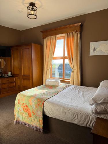 a bedroom with a large bed and a window at Crown & Anchor Inn in Brough