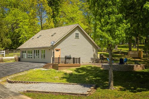 a small house with a porch and a yard at Lakefront Suite Dock, No-Wake Cove & Firepit in Marion