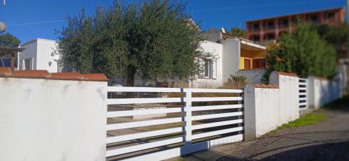 a white fence in front of a house at Sa Zirighetta in S'archittu Cuglieri