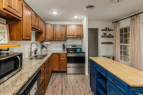 a kitchen with wooden cabinets and a blue island at Walkable 2BR Cottage in Downtown Marion in Marion