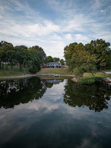 a view of a lake with a house in the background at Classic Lakeside Vacation Sleeps 9 in Marion