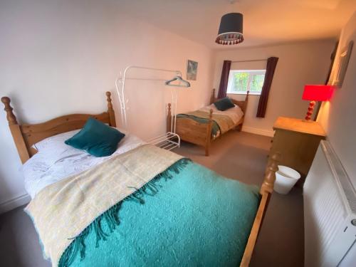 a bedroom with a bed and a window at Carmel Cottage - Forest of Dean in Lydbrook