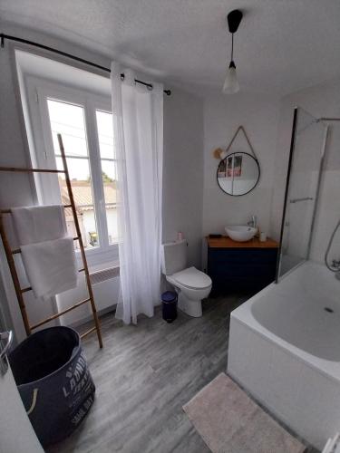 a bathroom with a toilet and a tub and a sink at Maisonette Syl' -vie in Cognac