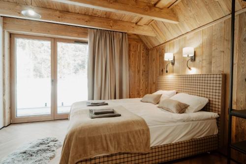 una camera da letto con un grande letto e una grande finestra di Drevia a Istebna