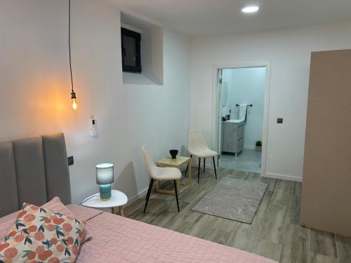 a bedroom with a bed and chairs and a bathroom at Victoria 1942 in Funchal