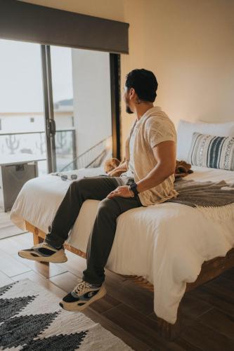 a man sitting on top of two beds at Casas VV in Valle de Guadalupe