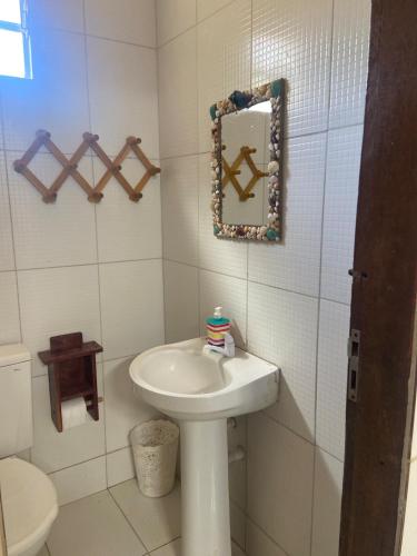 a white bathroom with a sink and a mirror at Casa Mar Alto in Icapuí